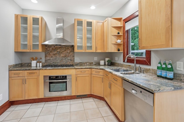 2410 Irving Ave S, Minneapolis, MN 55405 - kitchen featuring appliances with stainless steel finishes, wall chimney range hood, a sink, stone counters, and glass insert cabinets