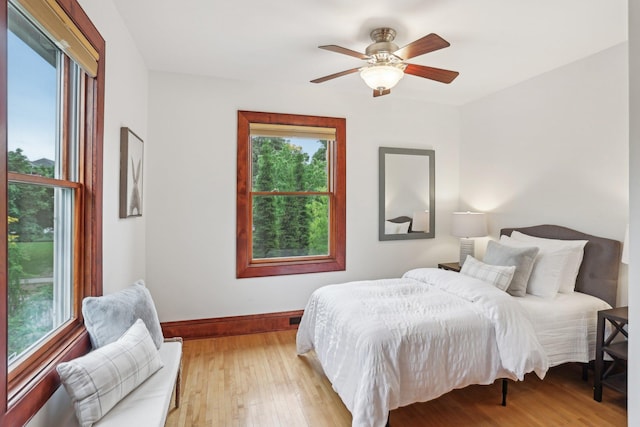 2410 Irving Ave S, Minneapolis, MN 55405 - bedroom featuring multiple windows, baseboards, light wood-type flooring, and a ceiling fan