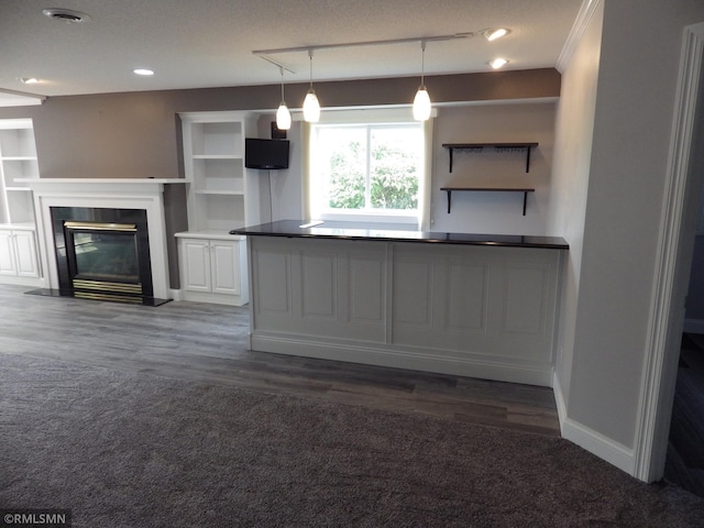 kitchen featuring baseboards, white cabinets, a glass covered fireplace, hanging light fixtures, and open shelves