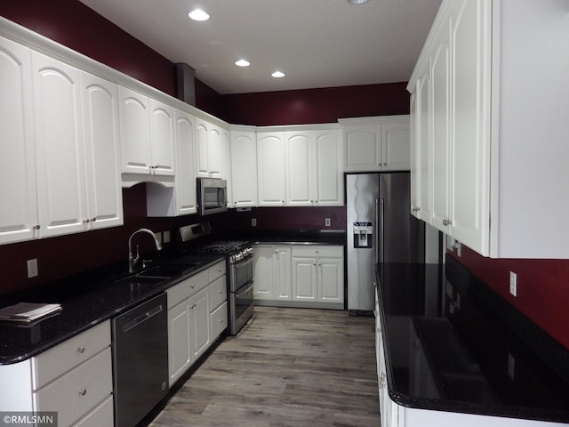 kitchen featuring stainless steel appliances, dark countertops, and a sink