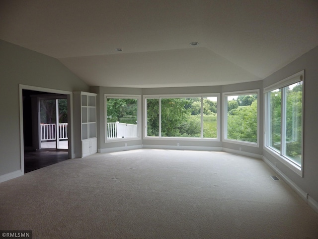 unfurnished sunroom featuring a wealth of natural light, visible vents, and vaulted ceiling