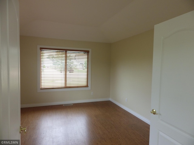 unfurnished room featuring wood finished floors, visible vents, and baseboards