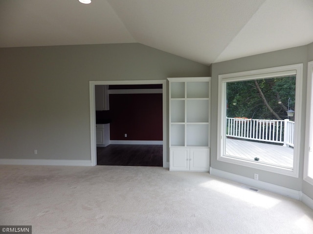 unfurnished living room featuring lofted ceiling, carpet flooring, visible vents, and baseboards