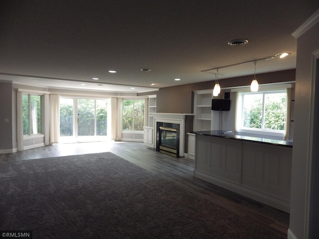 unfurnished living room featuring a premium fireplace, dark wood finished floors, visible vents, and recessed lighting