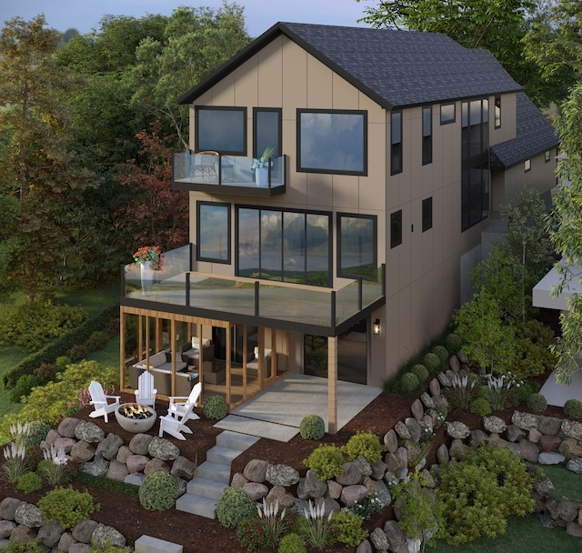 rear view of house with a patio area, a balcony, and a fire pit