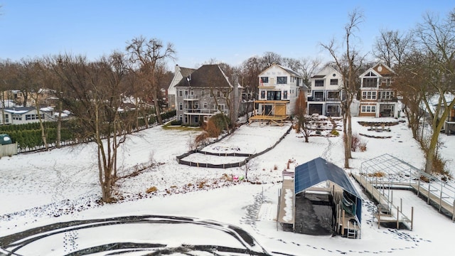 snow covered back of property with a residential view