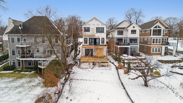 snow covered back of property featuring a residential view