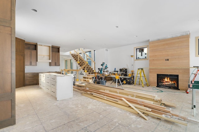 kitchen featuring a center island, a warm lit fireplace, and open shelves