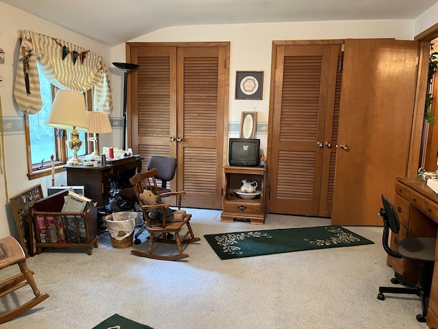 carpeted office space featuring vaulted ceiling