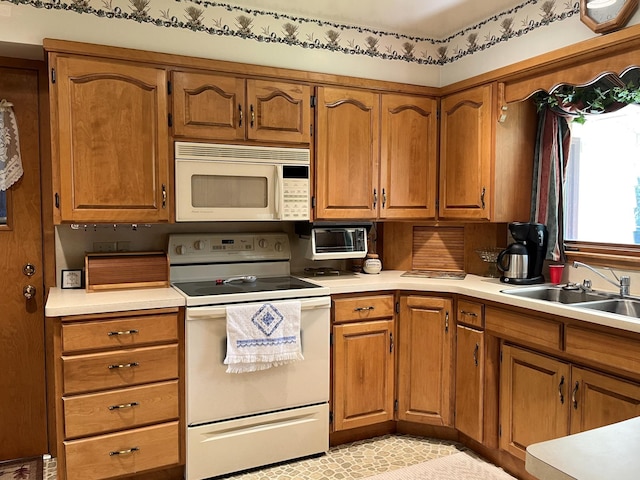 kitchen featuring white appliances, light tile patterned floors, and sink