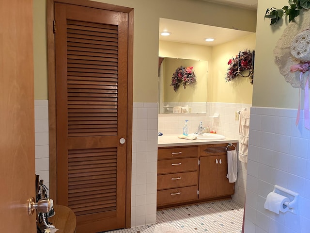 bathroom with tile walls, tile patterned flooring, tasteful backsplash, and vanity