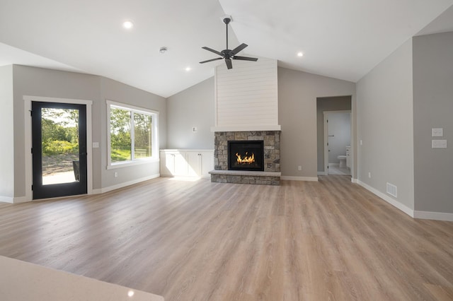 unfurnished living room featuring ceiling fan, lofted ceiling, a fireplace, and light hardwood / wood-style floors