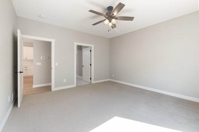 unfurnished bedroom featuring light carpet, ceiling fan, and ensuite bathroom