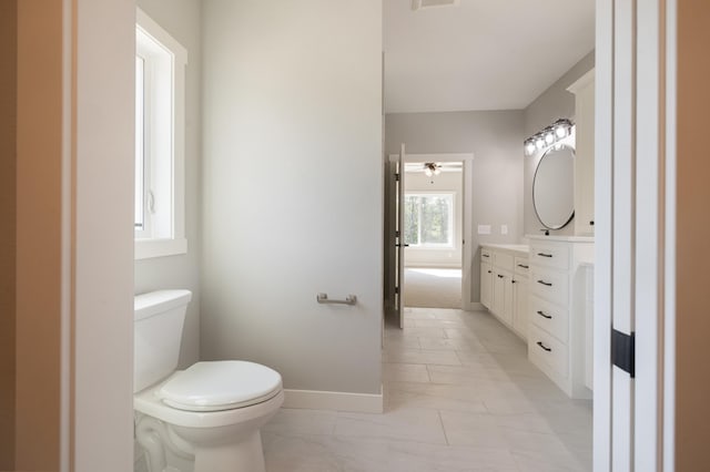 bathroom with ceiling fan, vanity, and toilet