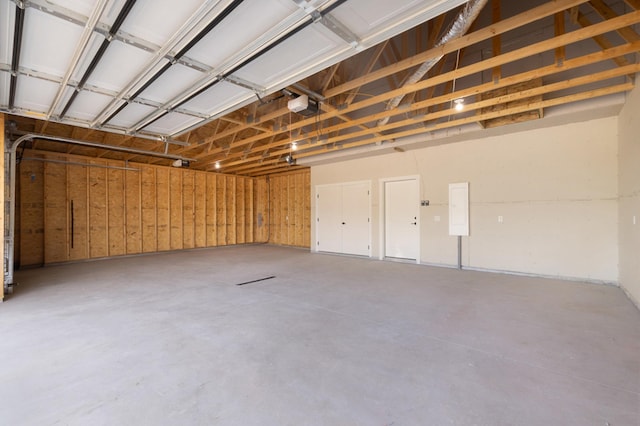 garage with a garage door opener and electric panel