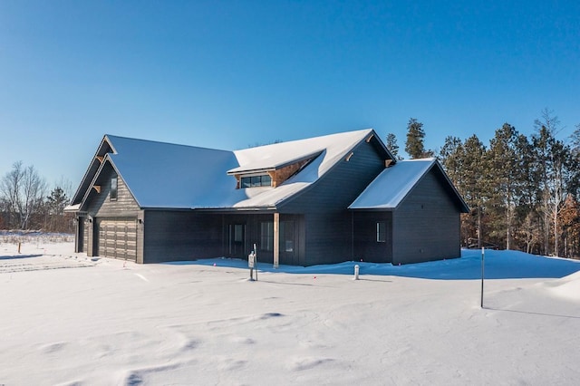 snow covered property with a garage