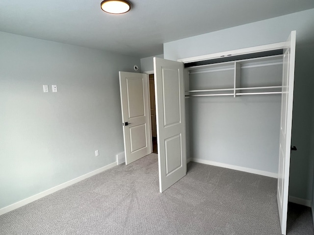 unfurnished bedroom with light carpet and a closet