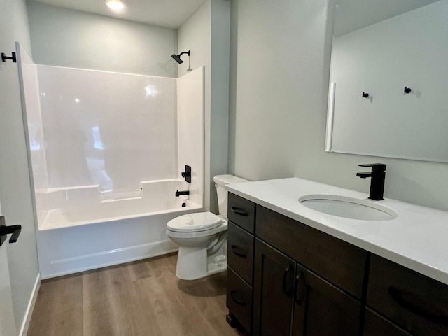 full bathroom featuring hardwood / wood-style floors, vanity, toilet, and shower / tub combination