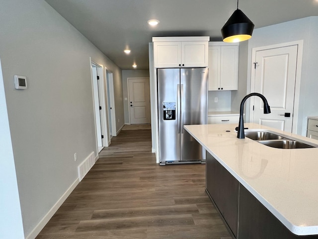 kitchen featuring dark hardwood / wood-style flooring, sink, a center island with sink, white cabinets, and stainless steel fridge with ice dispenser