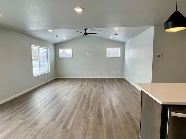 unfurnished living room featuring vaulted ceiling, light hardwood / wood-style flooring, and ceiling fan