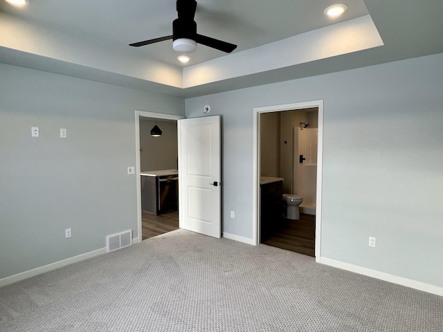 unfurnished bedroom with carpet, ensuite bath, and ceiling fan