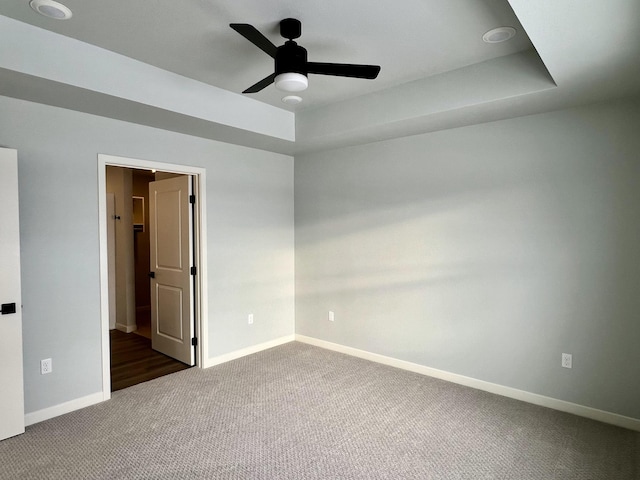 spare room with dark colored carpet and ceiling fan