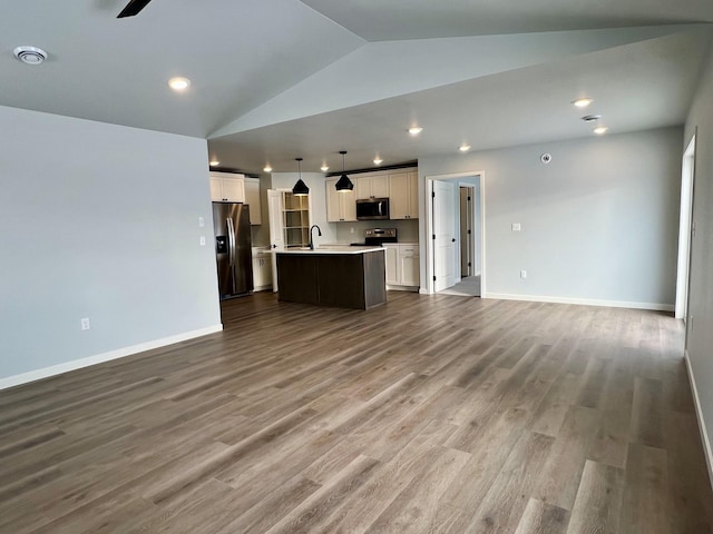 unfurnished living room with hardwood / wood-style floors, vaulted ceiling, ceiling fan, and sink