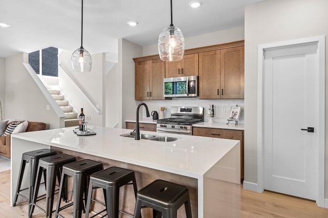 kitchen featuring pendant lighting, a breakfast bar area, sink, and appliances with stainless steel finishes