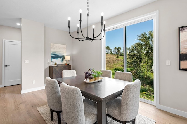 dining room with light hardwood / wood-style flooring and a notable chandelier