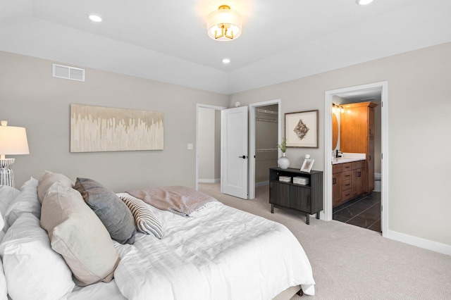 carpeted bedroom featuring ensuite bathroom