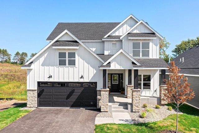 view of front facade featuring aphalt driveway, a garage, board and batten siding, and roof with shingles