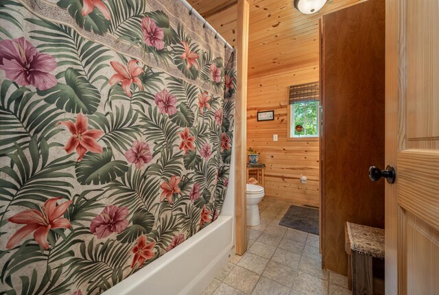 bathroom featuring wood walls, toilet, tile patterned floors, and shower / bath combo