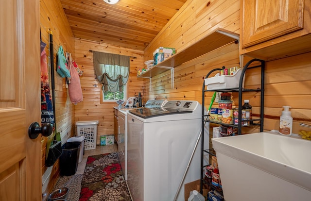 washroom with sink, wood walls, washing machine and dryer, and wooden ceiling