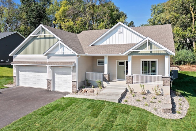 craftsman-style house with a garage, covered porch, and a front lawn