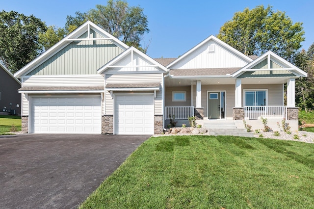 craftsman inspired home with a front yard, covered porch, and a garage