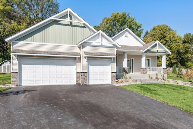 craftsman inspired home featuring a front lawn, a garage, and a porch