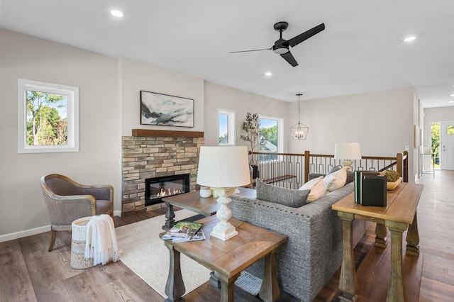 living room with ceiling fan, a wealth of natural light, a fireplace, and hardwood / wood-style flooring