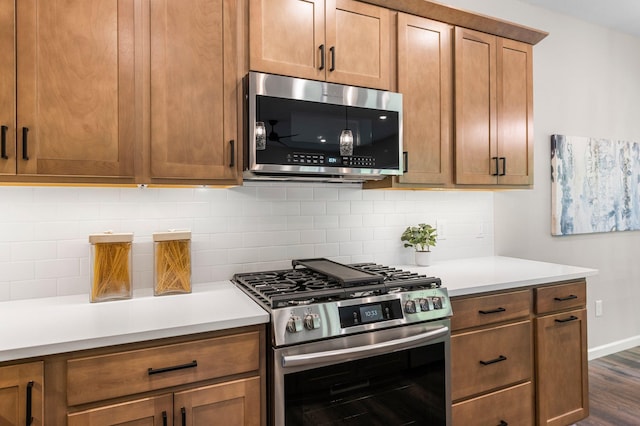 kitchen featuring stainless steel appliances, dark hardwood / wood-style flooring, and tasteful backsplash