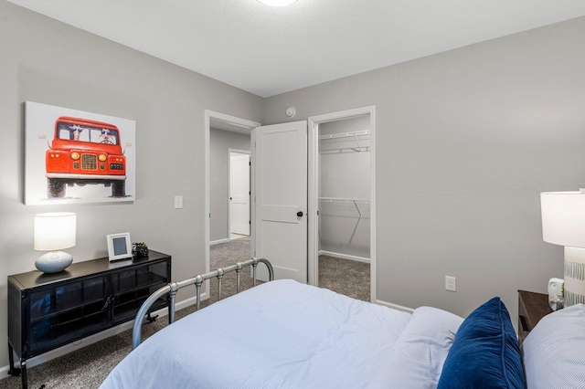 bedroom with a closet, a spacious closet, and carpet floors