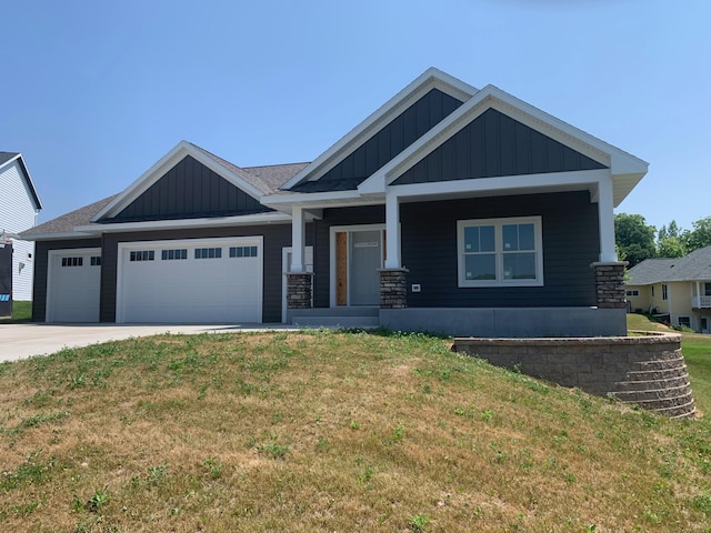 craftsman house featuring a garage and a front lawn