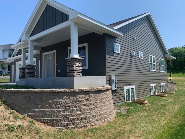 view of home's exterior featuring a porch and a yard