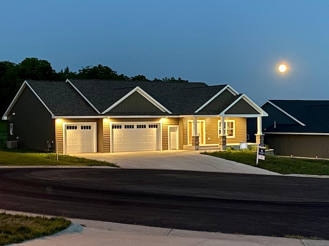 view of front of house with central air condition unit, driveway, and an attached garage