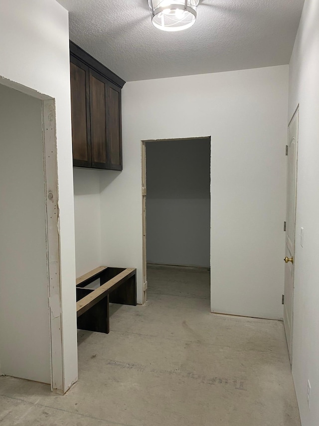 mudroom featuring a textured ceiling and concrete flooring