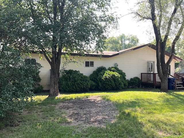 view of home's exterior with a deck and a yard