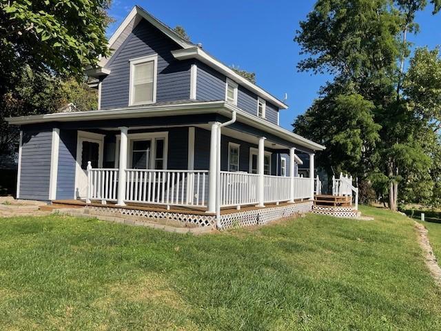 exterior space featuring a lawn and covered porch