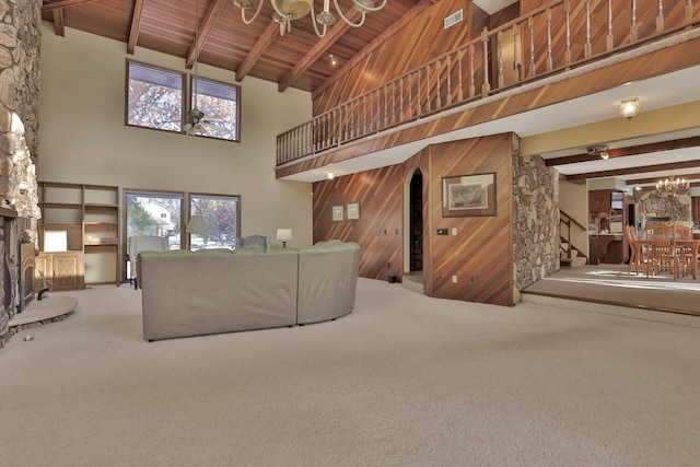 10834 178th Cir NW, Elk River, MN 55330 - living room featuring a chandelier, high vaulted ceiling, wood ceiling with exposed beams, wood walls, and carpet