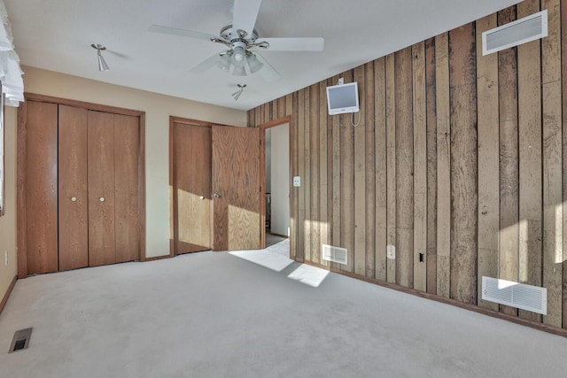 10834 178th Cir NW, Elk River, MN 55330 - unfurnished bedroom featuring two closets, carpet flooring, wood walls, and ceiling fan