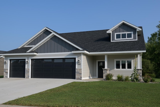 craftsman inspired home with covered porch, a garage, and a front yard