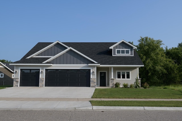 craftsman house with a front yard and a garage