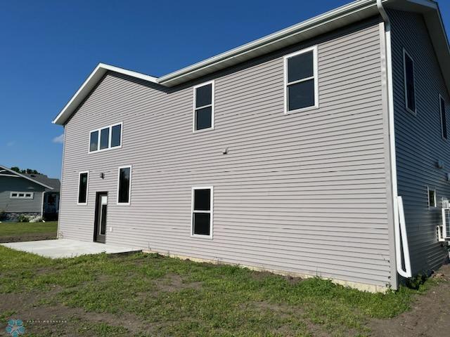 back of house with a patio and a lawn